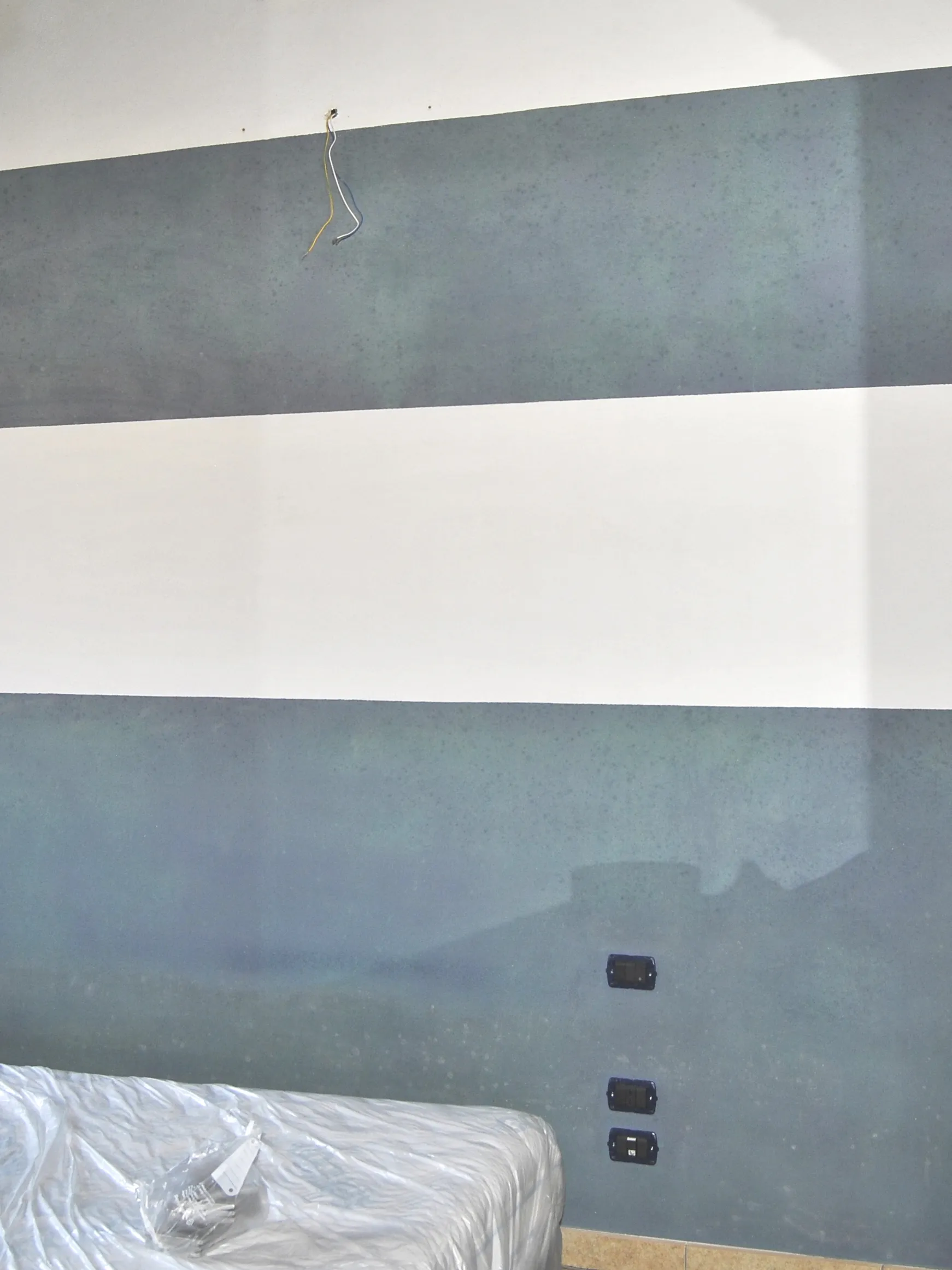 Parete a righe della camera da letto di Metro Room a Monastir, secondo lato, prima dell'intervento